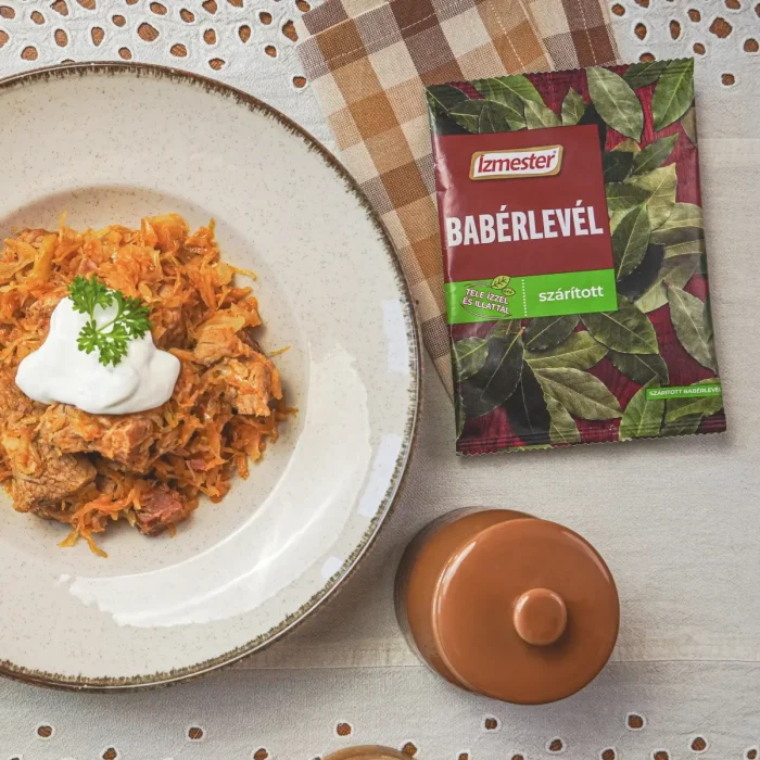 Székelykáposzta fehér tányérban asztalon, mellette kockás konyharuha