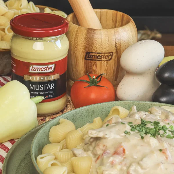 Mustáros tokány asztalon tányérban mellette paprika, üveges mustár