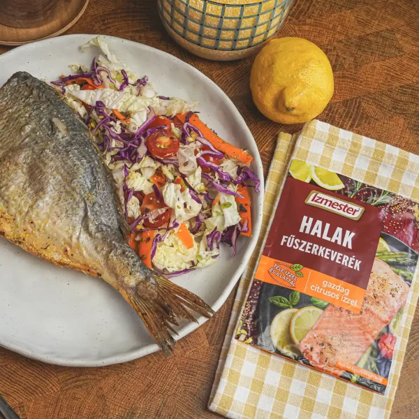 Sült hal tányéron, mellette saláta és halak fűszerkeverék tasakban