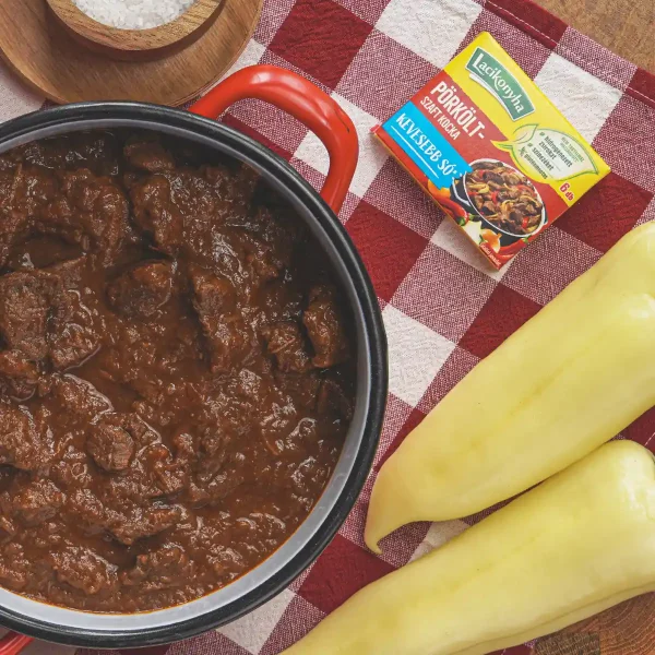 marhapörkölt piros lábasban felülnézetből asztalon zöldpaprikával