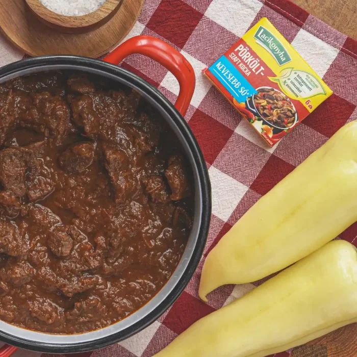 marhapörkölt piros lábasban felülnézetből asztalon zöldpaprikával