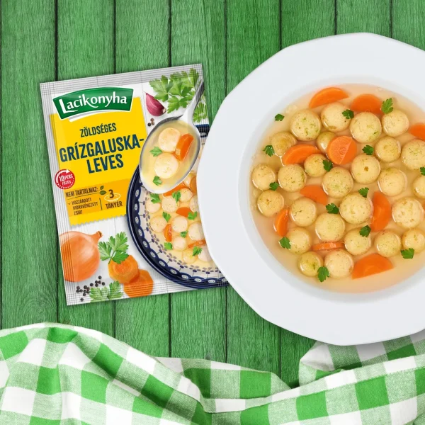 Zöldséges grízgaluskaleves házias stílusú levespor tasak faerezetes asztalon, mellette fehér tányérban grízgaluskaleves és zöld-fehér kockás terítővel