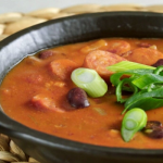 babgulyás tartalmas leves fekete tálban, hagymával tálalva