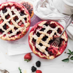 bogyós gyümölcsös pite sütemény asztalon, mellette eper, szeder dekorációként