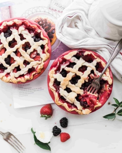 bogyós gyümölcsös pite sütemény asztalon, mellette eper, szeder dekorációként