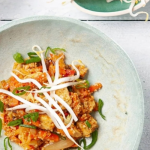 Csirkés quinoa egytálétel saláta babcsírával tálalva tányéron