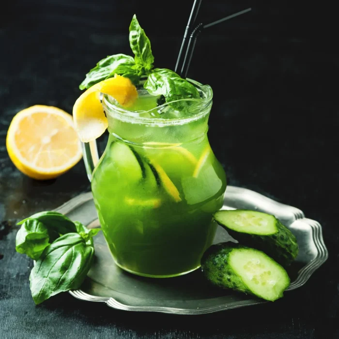 Házi limonádé jeges ital uborkával, mentával, bazsalikommal üveg pohárban, citromkarikával tálalva