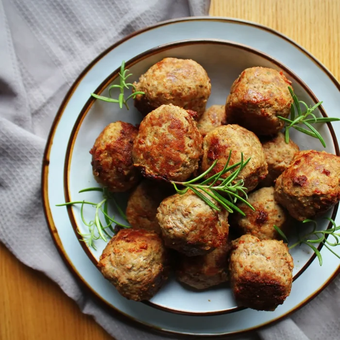 Fasírt golyók egy tányéron, friss rozmaringgal tálalva