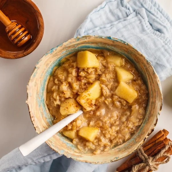 Almás zabkása fahéjszórással tálban, kanállal