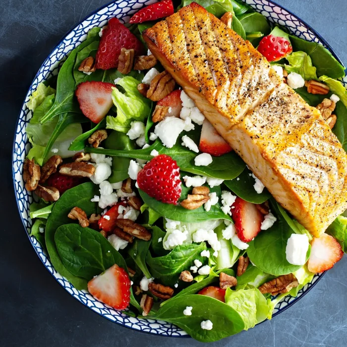 Epres saláta sült lazaccal tányérban felülnézetből