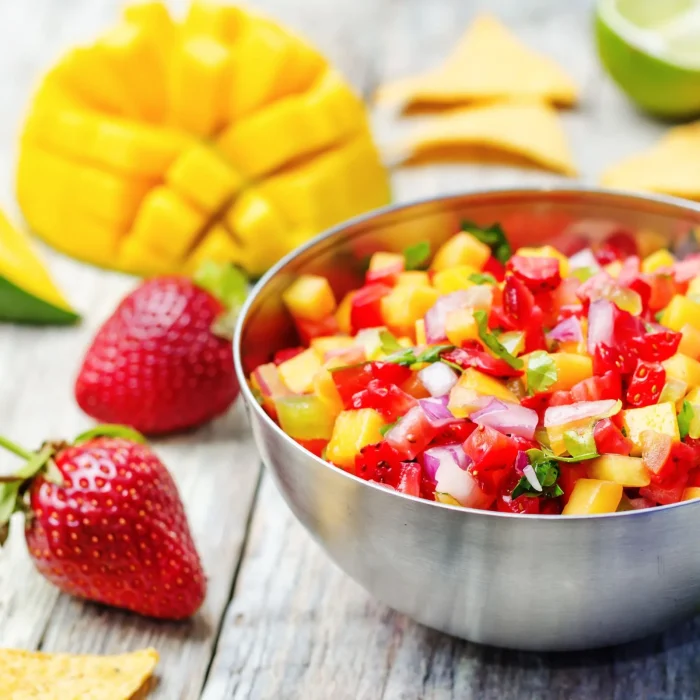 Friss gyümölcssaláta eperrel, ananásszal, mentával egy tálban