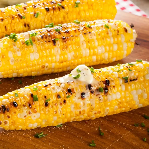 Fokhagymás fűszersó vajjal egy cső sült kukoricára kenve