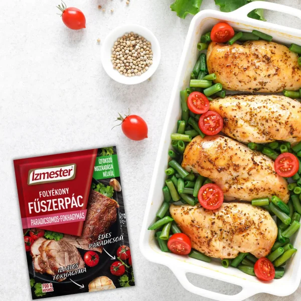 Fehér asztalon fehér sütőedényben sült csirkemell szeletek salátaágyon, paradicsommal tálalva, mellette paradicsomos-fokhagymás folyékony fűszerpác tasakos termék