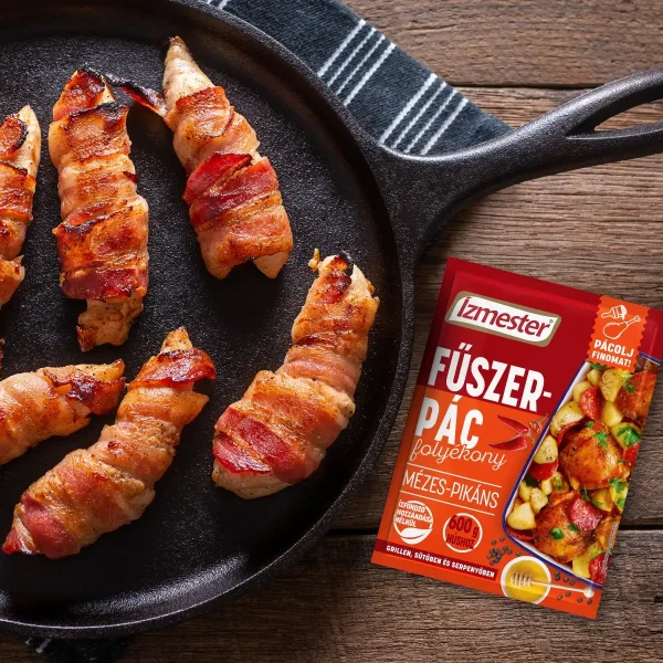 Baconba göngyölt csirkemell csíkok serpenyőben mellette egy tasak mézes-pikáns folyékony fűszerpác