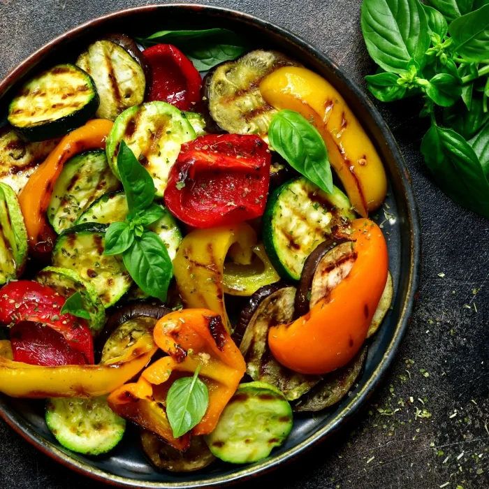 Grillezett cukkini, paprika és padlizsán vegyesen egy sötétszürke tányérban