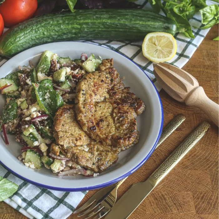 Sült karaj uborkasalátával fehér tányéron