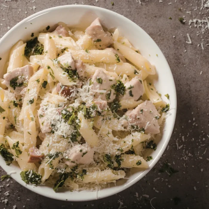 Tésztasaláta fehér tányérban mézes mustáros szósszal felülnézetből