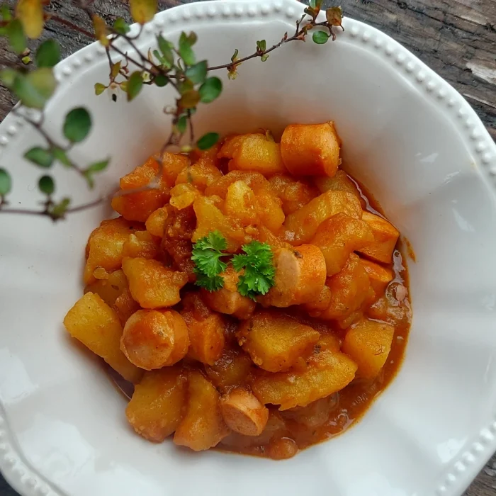 Paprikás krumpli virslivel fehér tányérban felülnézetből