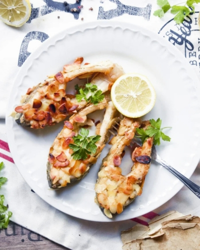 Mandulabundás pontypatkó félbevágott citrommal tálalva tányéron, ünnepi asztalon