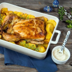 Tanyasi egész csirke tepsiben burgonyaágyon tálalva, mellette szósz