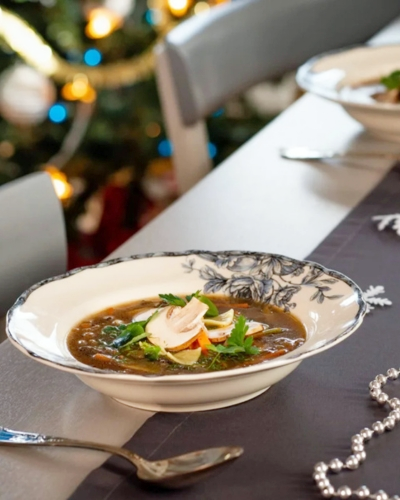 Gombaleves karácsonyi asztalon dekorációkkal, fehér tányérban