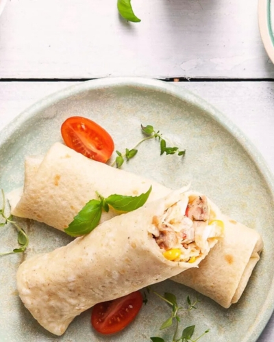 Csirkés palacsinta kukoricával és kínai kellel félbevágva tányéron, paradicsomkarikával díszítve