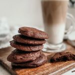 Csokis keksz fa deszkán, mögötte kakaós-tejes ital