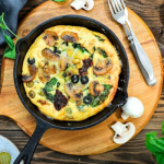 Frittata szárított paradicsommal serpenyőben fa deszkán tálalva