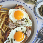 Holstein szelet tükörtojással, sós szerdellával, kapribogyóval tálalva tányéron, sült krumplival