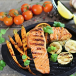 Mézes-mustáros grillezett-lazac tányéron, grillezett zöldségekkel tálalva