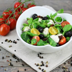 Mozzarellás paradicsomsaláta salátás tálban, paradicsomfürtökkel díszítve