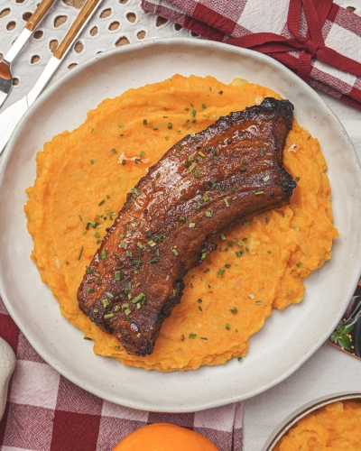 Narancsos sült hús oldalas édesburgonyapürével tányéron