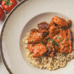 Fűszerpaprikás-paradicsomos csirke tejszínes szószban, bulgurral tálalva tányéron