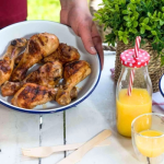 Sörben pácolt csirkecomb tálban, mellette narancslé