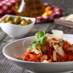 Sült paprikás pesztós tészta penne tányérban friss bazsalikommal tálalva