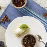 Sült szilva diós morzsában fehér tányéron tálalva friss mentalevéllel