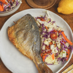 Sütőben sült hal ropogós panírban salátával tálalva tányéron